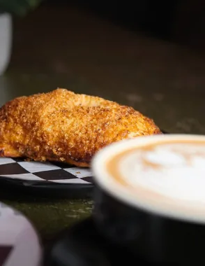 Un pastelito y un café servidos en la mesa