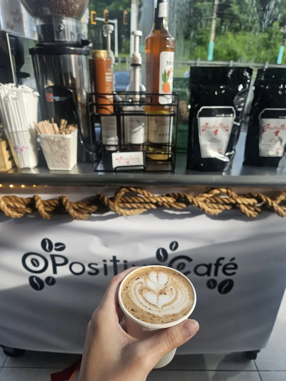Un latte de O Positivo frente al carrito de café en una actividad