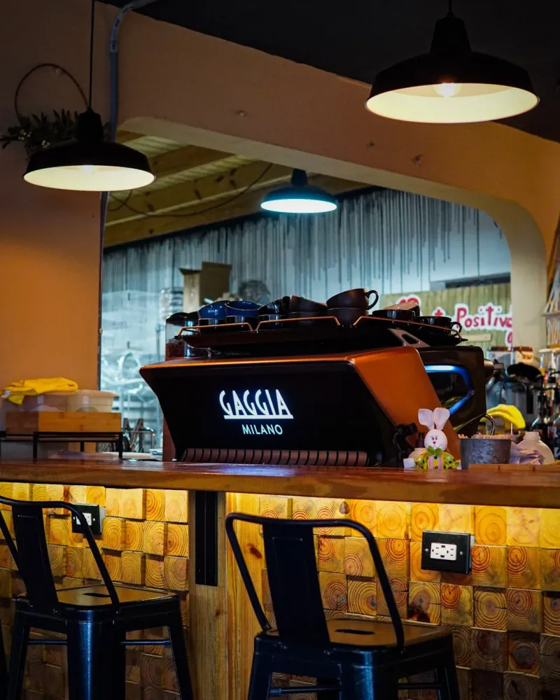 La barra de O Positivo Café con su máquina de espresso Gaggia y las lámparas encendidas